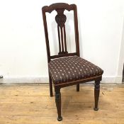 An Art Nouveau style chair with stylised flower splat above a multiple flowerhead upholstered seat