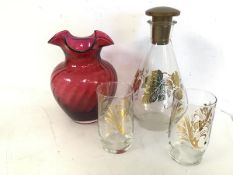 A 1970s pyrex decanter with plastic stopper and gilt leaf decoration and two drinking glasses with