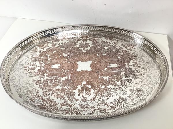 An Epns drinks tray with raised pierced edge and foliate and C scroll decorated top, on squat