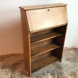An oak writing bureau with fall front enclosing a fitted interior with an arrangement of pigeonholes