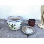 A large ceramic planter, with blue and white decorated rim above a polychrome floral decorated