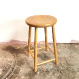 A beech stool with circular top on four turned supports united by box stretcher (60cm x 35cm)