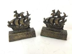 A pair of brass doorstops, both in the form of a sailing warship and inscribed verso, A Galleon in