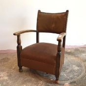 A 1920s/30s low open armchair with faux leather back, with chocolate brown upholstered seat, on