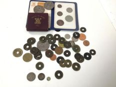 A collection of coins including a George III five pence, a small Queen Victoria token inscribed with