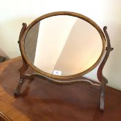 An Edwardian hinged dressing table mirror, the oval glass supported by scroll supports (45cm x