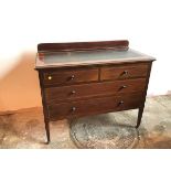 An Edwardian mahogany chest of drawers with ledge back above tooled leather panel, with two short