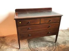 An Edwardian mahogany chest of drawers with ledge back above tooled leather panel, with two short