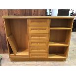 A modern oak bookcase with central bank of six drawers, flanked by adjustable shelves on plinth base