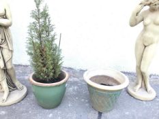 A pair of ceramic planters, one with a glazed green body, the other with a verdigris style glaze and