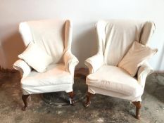 A pair of wing back Parker Knoll armchairs, both in foliate pattern loose cover in ivory, on