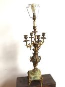A candelabra with four foliate branches radiating from a single stem, emerging from classically
