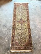 A Persian silk pile rug, the central medallion within an ivory field, with scrolling vine and flower