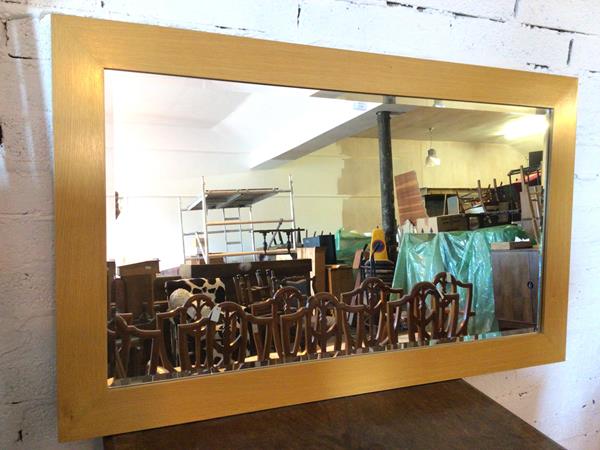 A modern wall mirror, the bevelled glass within an oak frame (90cm x 150cm)