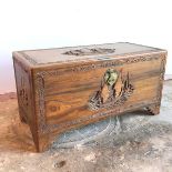 A Chinese hardwood trunk with maritime scene carved to top and sides within Chinese design border,