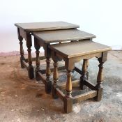 A set of three oak nesting tables, with rectangular tops on turned supports united by stretchers,