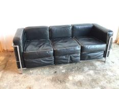 A modernist Grand Comfort three seater sofa in black leather on tubular frame (70cm x 174cm x 71cm)