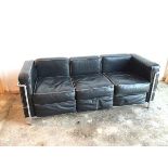 A modernist Grand Comfort three seater sofa in black leather on tubular frame (70cm x 174cm x 71cm)