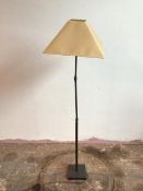 A metal standard lamp with ball hinge lamp holder and two adjustable hinges to stem, on square base,