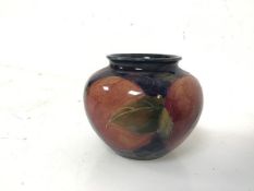 A small Moorcroft vase, of urn form with fruit decoration, stamped Moorcroft to base (6cm x 8cm)