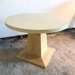 A modern light oak breakfast table, the circular top with chanelled edges, on tapering support, on
