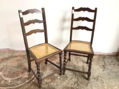 A pair of 1920s/30s oak side chairs, with moulded ladder back above caned seats, with barley twist