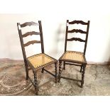 A pair of 1920s/30s oak side chairs, with moulded ladder back above caned seats, with barley twist