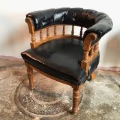 An Edwardian oak library tub chair, the buttoned leather upholstered horseshoe back, supported on