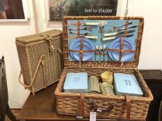 A Coracle wicker picnic basket, fitted with knives, forks, spoons, plates (one lacking), saucers