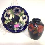 A Moorcroft pottery dish, circular, in the Pansies pattern, against a blue ground, green painted