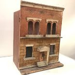 A late 19th century painted wooden doll's house, modelled as a brick two-storey town house, the