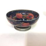 A Tudric Moorcroft pottery bowl, in the Pomegranate pattern, against a shaded blue / green ground,