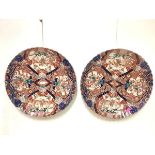 A striking pair of large Japanese Imari porcelain chargers, Meiji period, each with scalloped rim