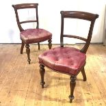 A pair of Victorian mahogany side chairs, with curved back rails and buttoned-leather seats. 90cm by