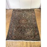 A hand-knotted carpet of North-West Persian design, the black field with central medallion and