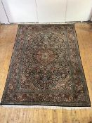 A hand-knotted carpet of North-West Persian design, the black field with central medallion and