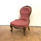 A Victorian walnut nursing chair, c. 1860, the shaped button-upholstered back with carved crest