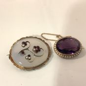 An Edwardian 15ct gold amethyst and seed pearl brooch, the oval-cut stone within a band of seed