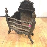 A cast-iron fire basket in the Neo-Classical style, with serpentine basket and cast-brass finials.