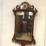 A George III parcel-gilt walnut fretwork mirror, the (distressed) plate within a shaped gilt slip,