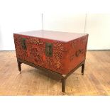 A Chinese red lacquered leather trunk, mid-20th century, the hinged top with later perspex cover,