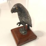 A 19th century white-metal model of a parrot, modelled with one claw upraised and fitted with