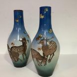 An unusual pair of Satsuma vases, c. 1900/1920, of slender baluster form, boldly painted with Sika
