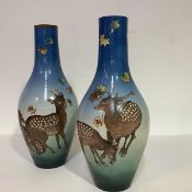 An unusual pair of Satsuma vases, c. 1900/1920, of slender baluster form, boldly painted with Sika