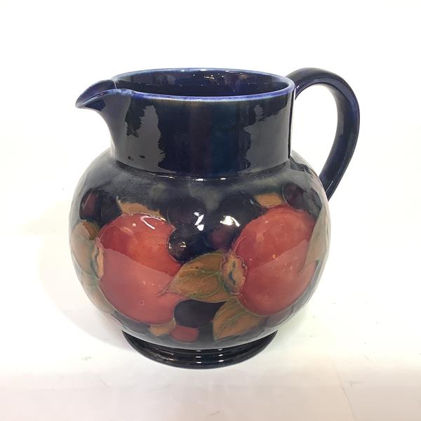 A Moorcroft pottery jug, in the Pomegranate pattern, of baluster form, with blue painted signature