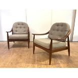 A pair of teak lounge chairs, probably Danish, each two-tone hoop back and downswept arms ending