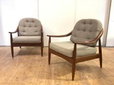 A pair of teak lounge chairs, probably Danish, each two-tone hoop back and downswept arms ending