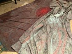 A 19th century woollen Paisley shawl, the central crimson reserve against a ground in greens,