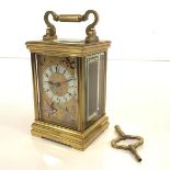 A late 19th century French brass carriage clock, the gilt dial with white enamel chapter ring and