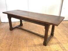 A 17th century style oak refectory table, the solid plank top above an arcaded frieze, on column